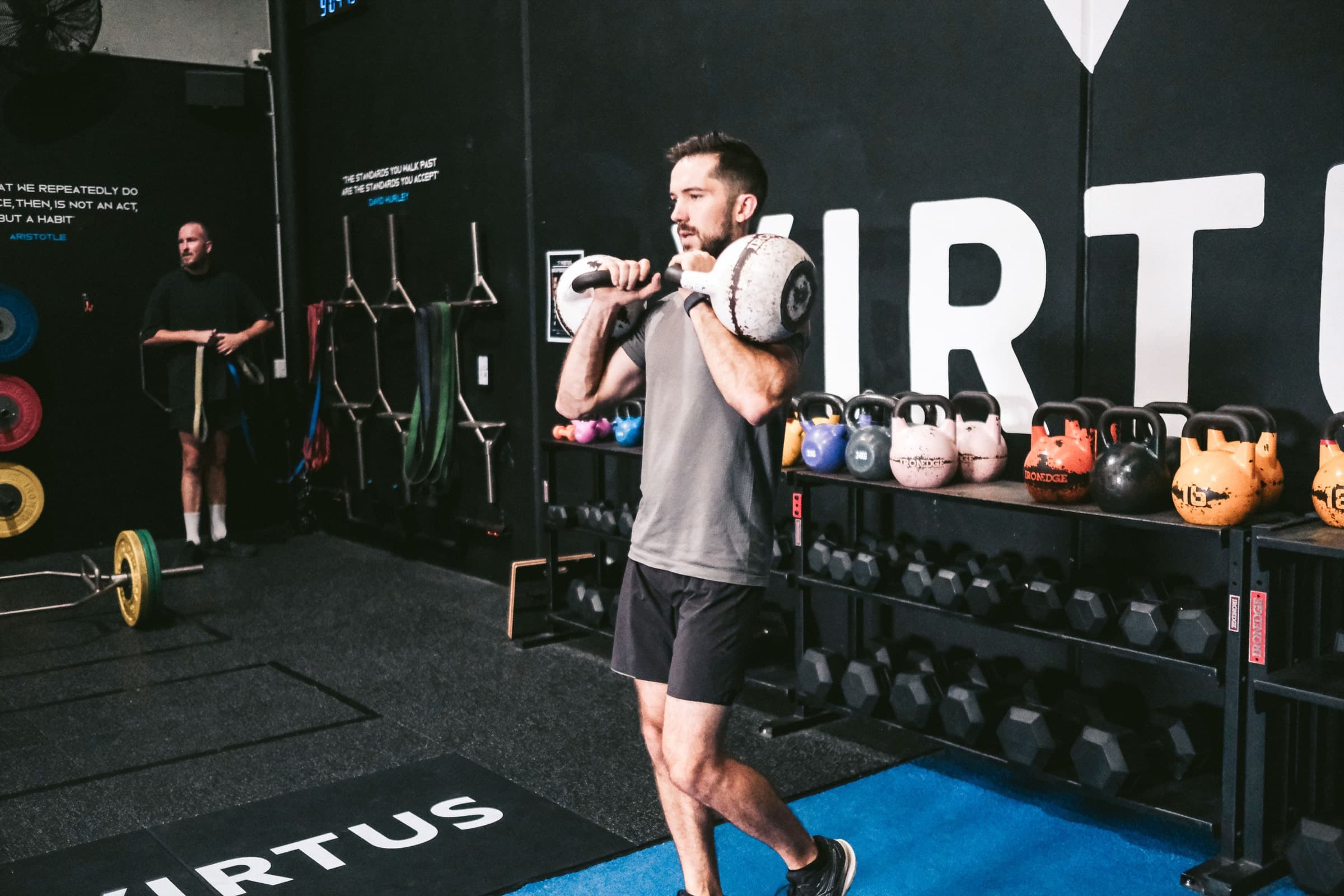 A coach working with a member on the Virtus training floor